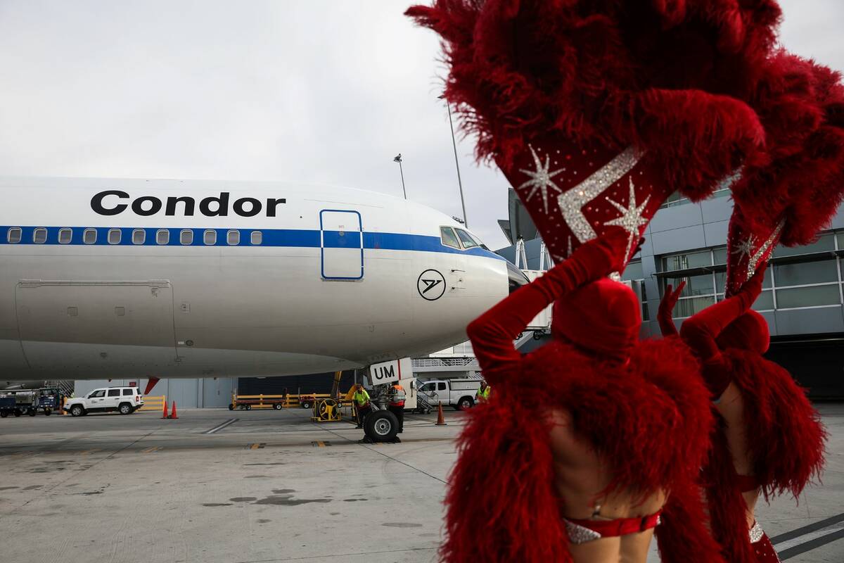 Showgirls greet a Condor plane, the first direct flight from Germany since the pandemic began, ...
