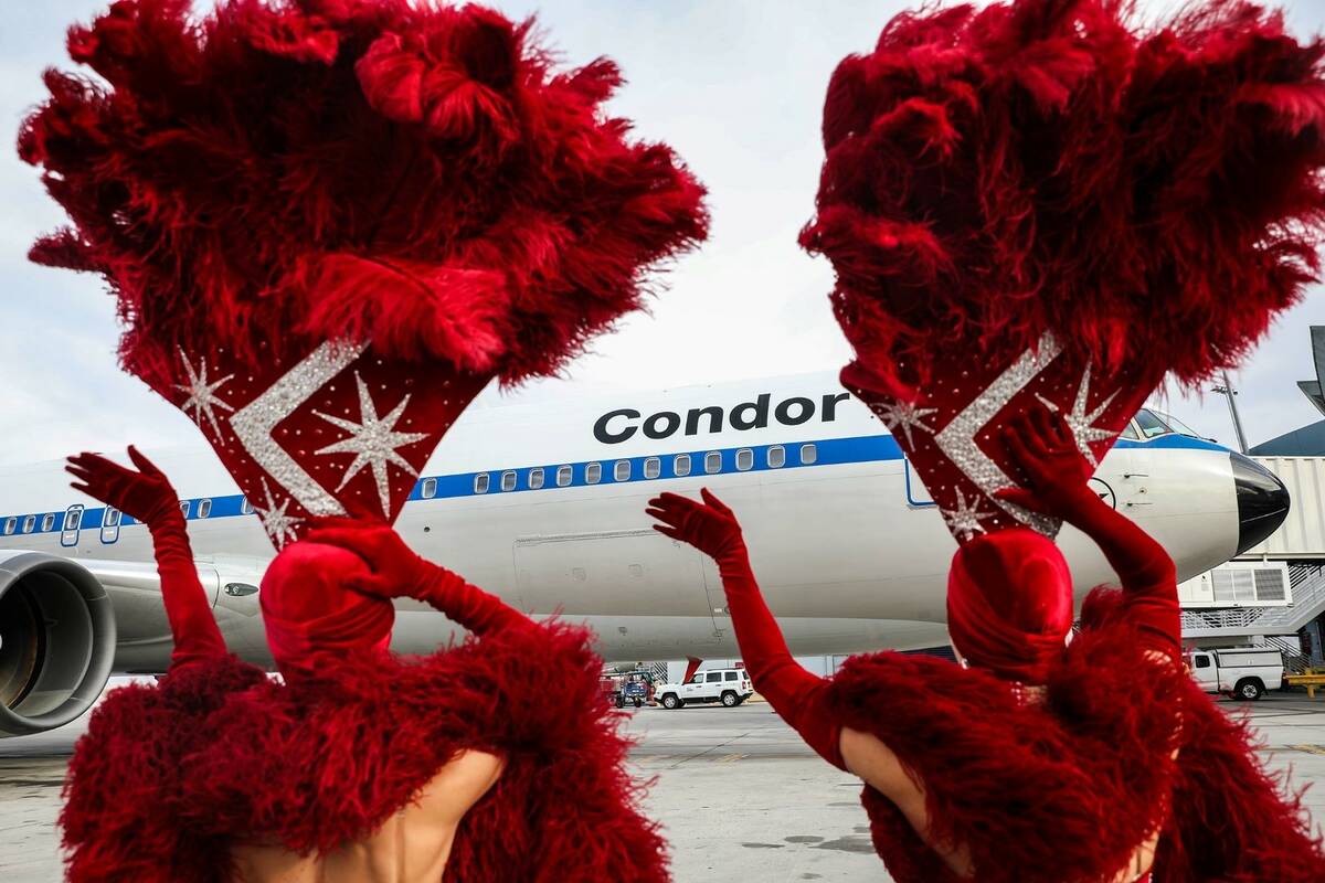 Showgirls greet a Condor plane, the first direct flight from Germany since the pandemic began, ...