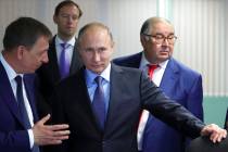 FILE - Russian President Vladimir Putin, center, listens to Lebedinsky GOK Managing Director Ol ...