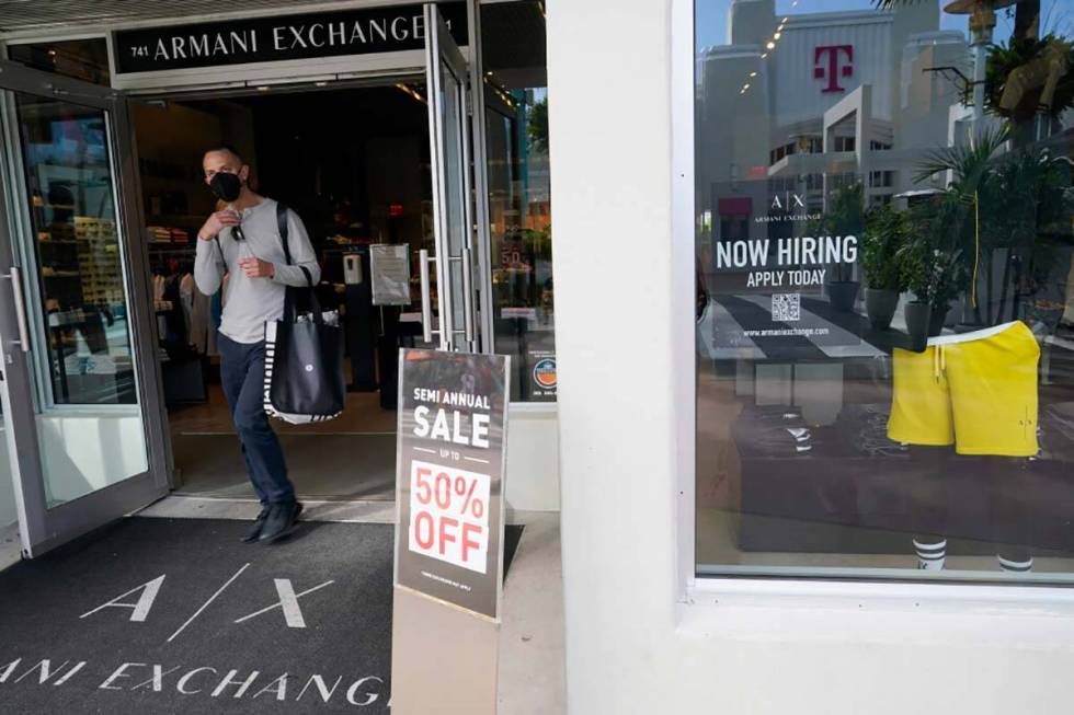 For sale and hiring signs are displayed at an Armani Exchange store, Friday, Jan. 21, 2022, in ...