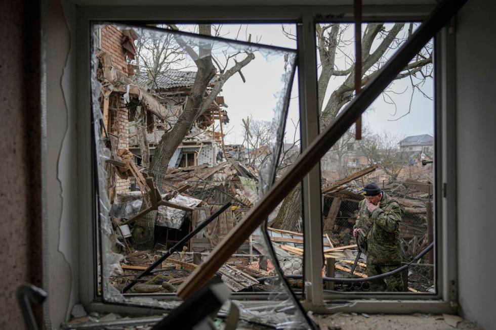 Andrey Goncharuk, 68, a member of territorial defense wipes his face in the backyard of a house ...