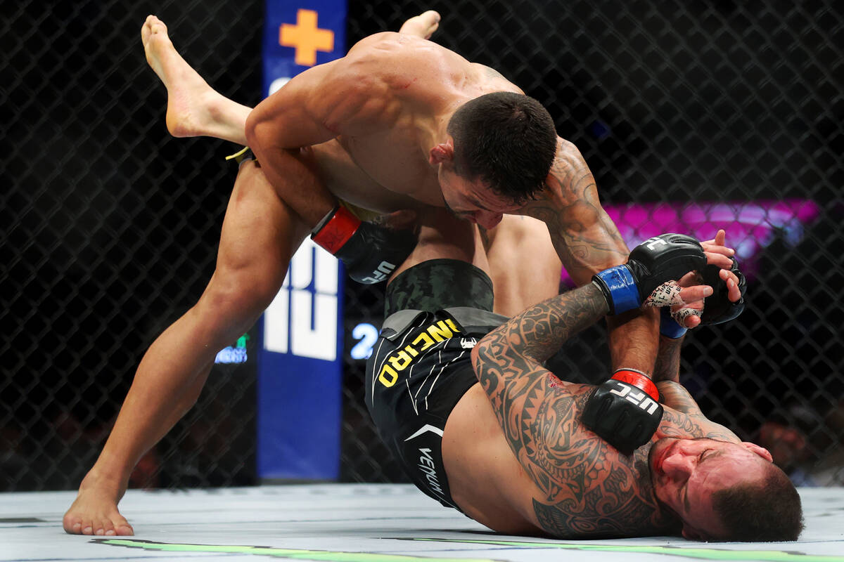 Rafael Dos Anjos, left, connects a punch against Renato Moicano in the third round of an UFC 27 ...