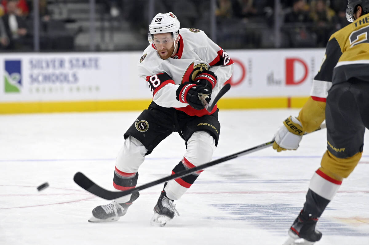 Ottawa Senators left wing Tim Stützle (18) hits the puck down the ice against the Vegas Go ...