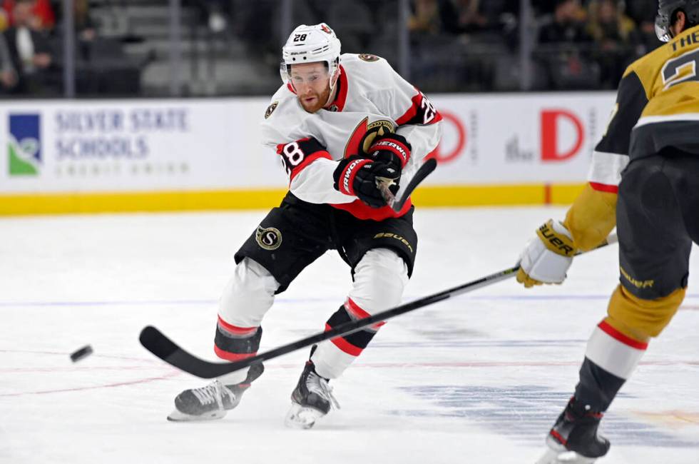 Ottawa Senators left wing Tim Stützle (18) hits the puck down the ice against the Vegas Go ...