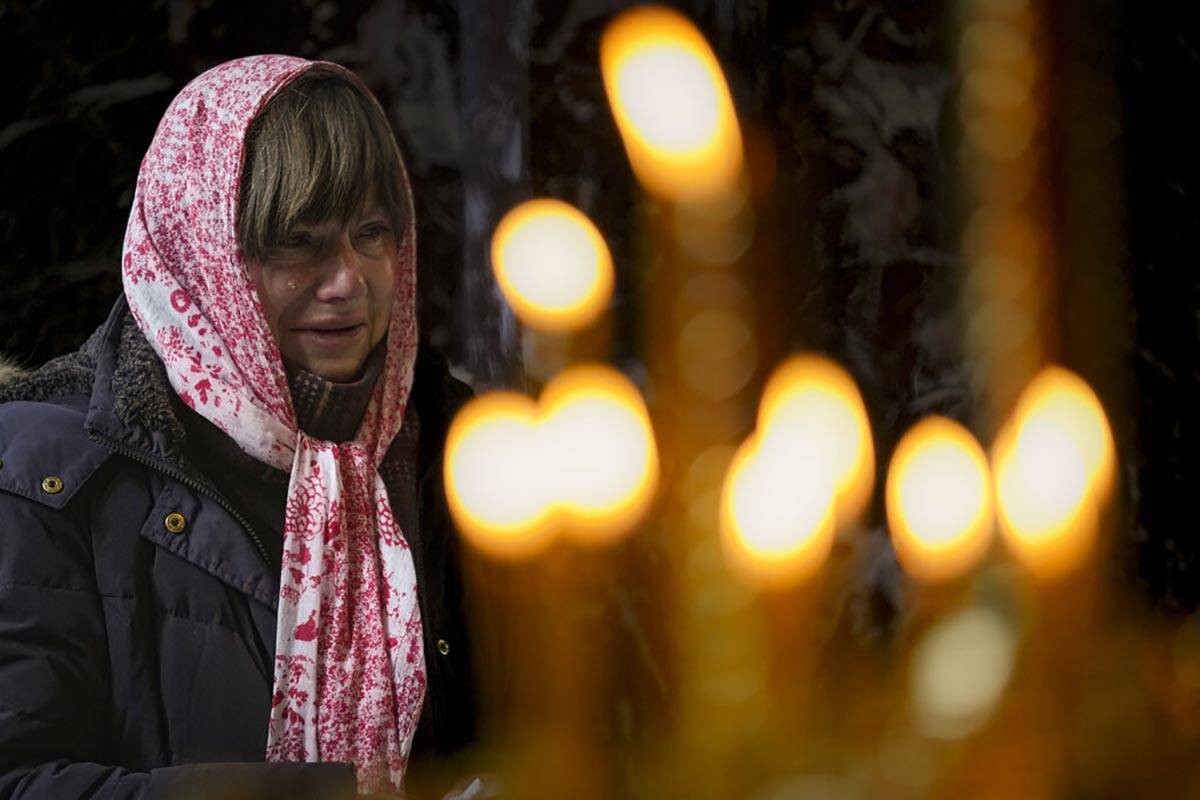 A woman cries during a religious service at the St Volodymyr's Cathedral in Kyiv, Ukraine, Sund ...