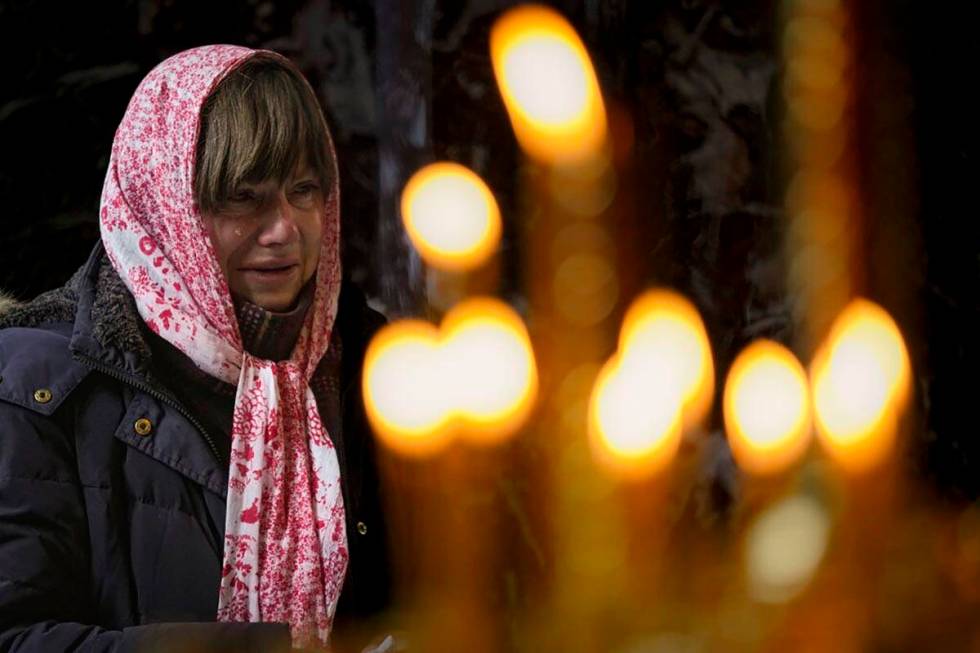 A woman cries during a religious service at the St Volodymyr's Cathedral in Kyiv, Ukraine, Sund ...