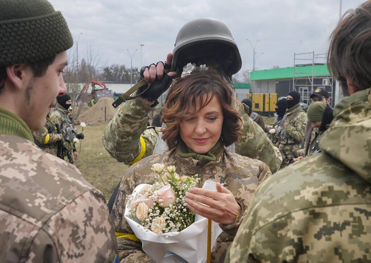 A soldier holds a helmet as a wedding crown during the wedding ceremony for members of the Ukra ...