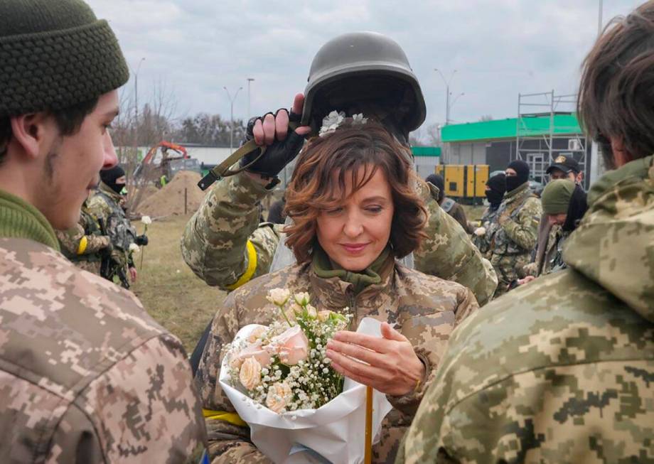 A soldier holds a helmet as a wedding crown during the wedding ceremony for members of the Ukra ...