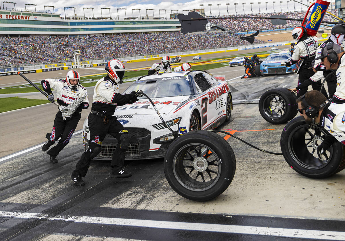 Pit crews work on NASCAR Cup Series driver Austin Cindric’s car during the Pennzoil 400 ...