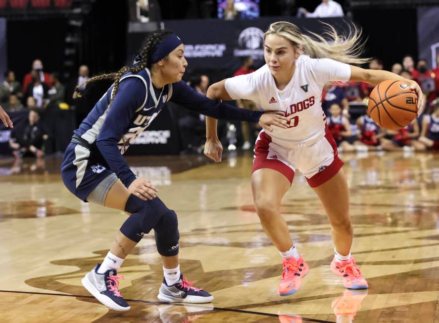 Fresno State Bulldogs guard Hanna Cavinder (0) drives against Utah State Aggies guard Shyla Lat ...