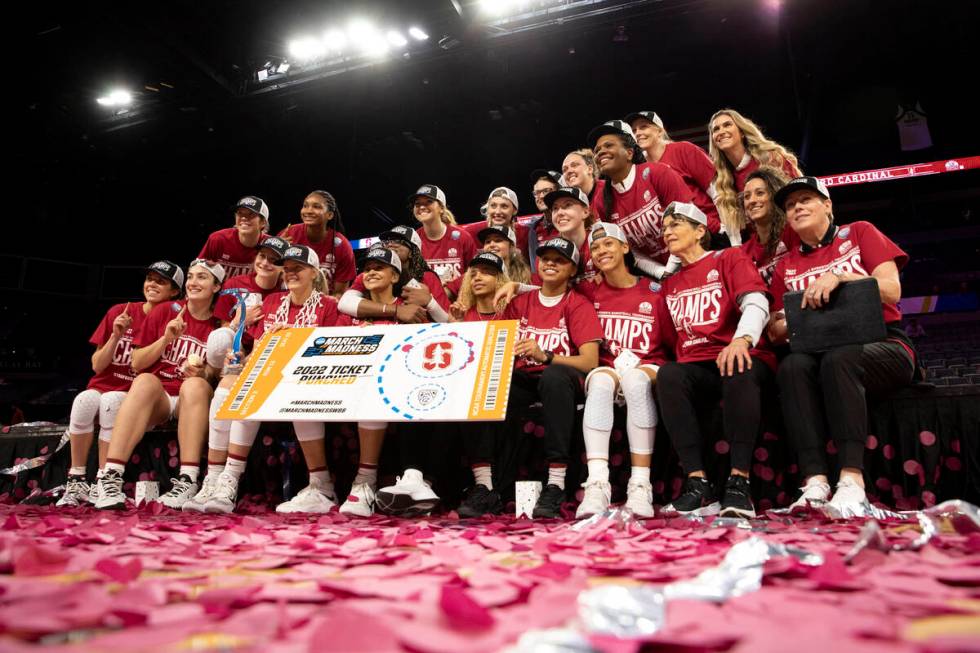 Members of the Stanford team poses for photos after winning an NCAA college basketball game for ...