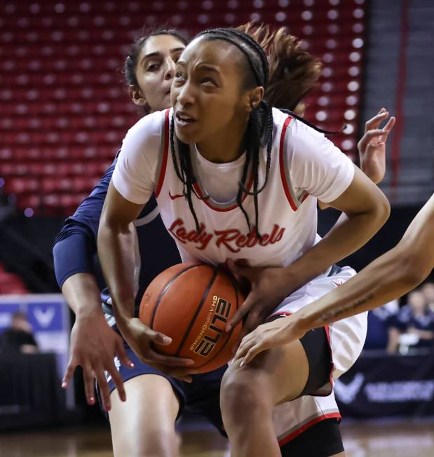 UNLV Lady Rebels guard Justice Ethridge (11) drives to the basket between Utah State Aggies gua ...