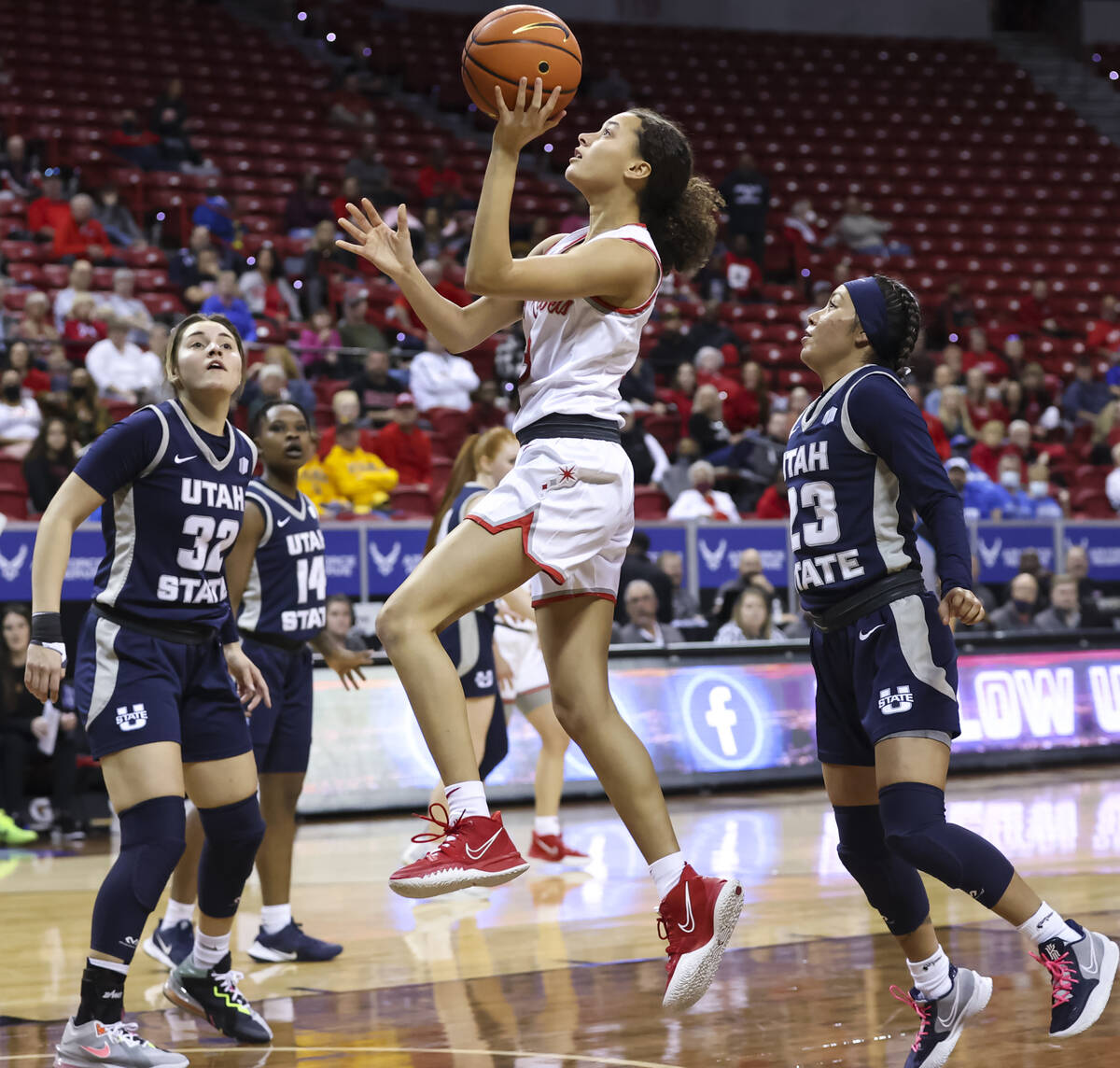 UNLV Lady Rebels guard Kiara Jackson (3) lays up the ball between Utah State Aggies guards Adry ...