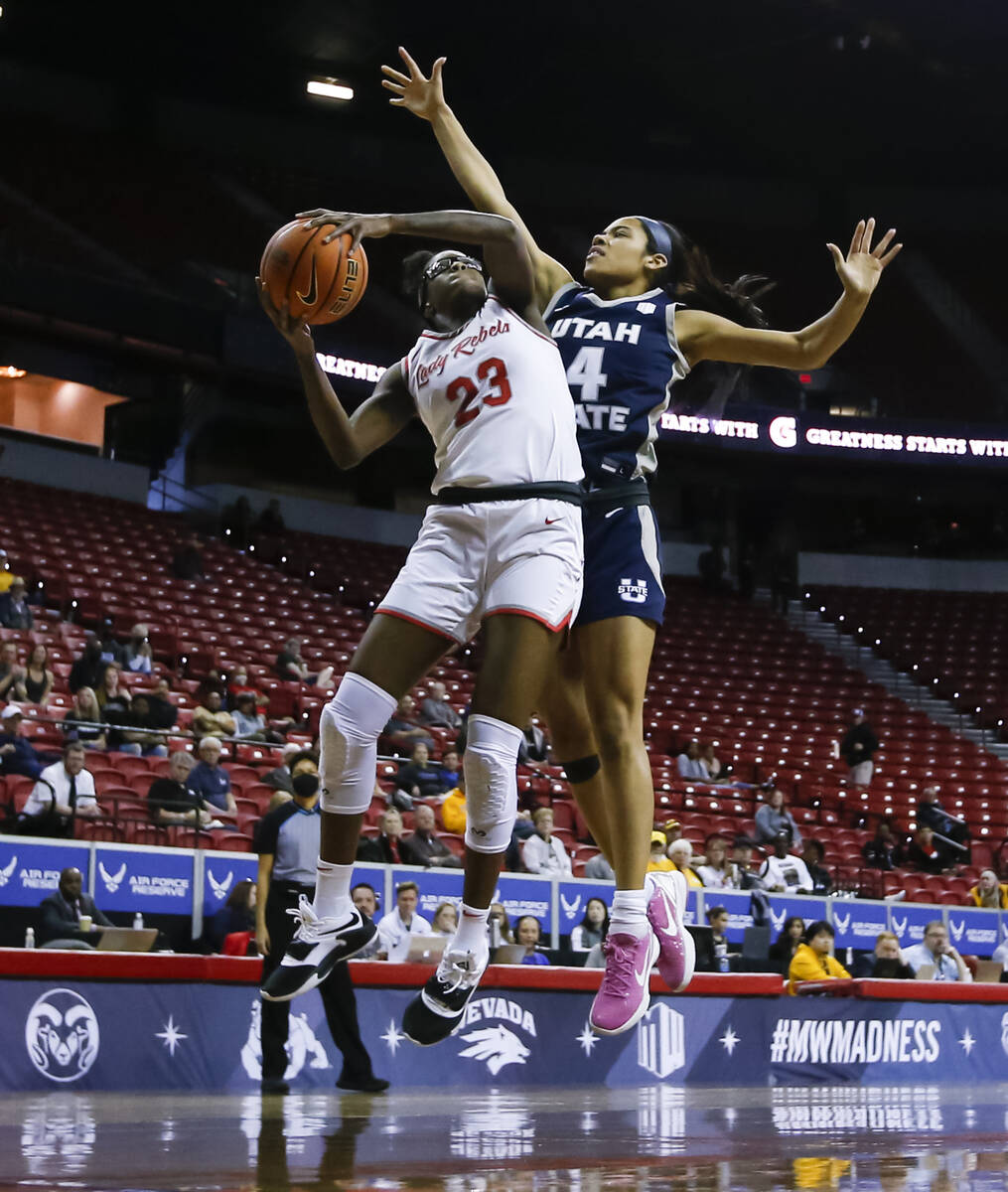 UNLV Lady Rebels center Desi-Rae Young (23) shoots under pressure from Utah State Aggies guard ...