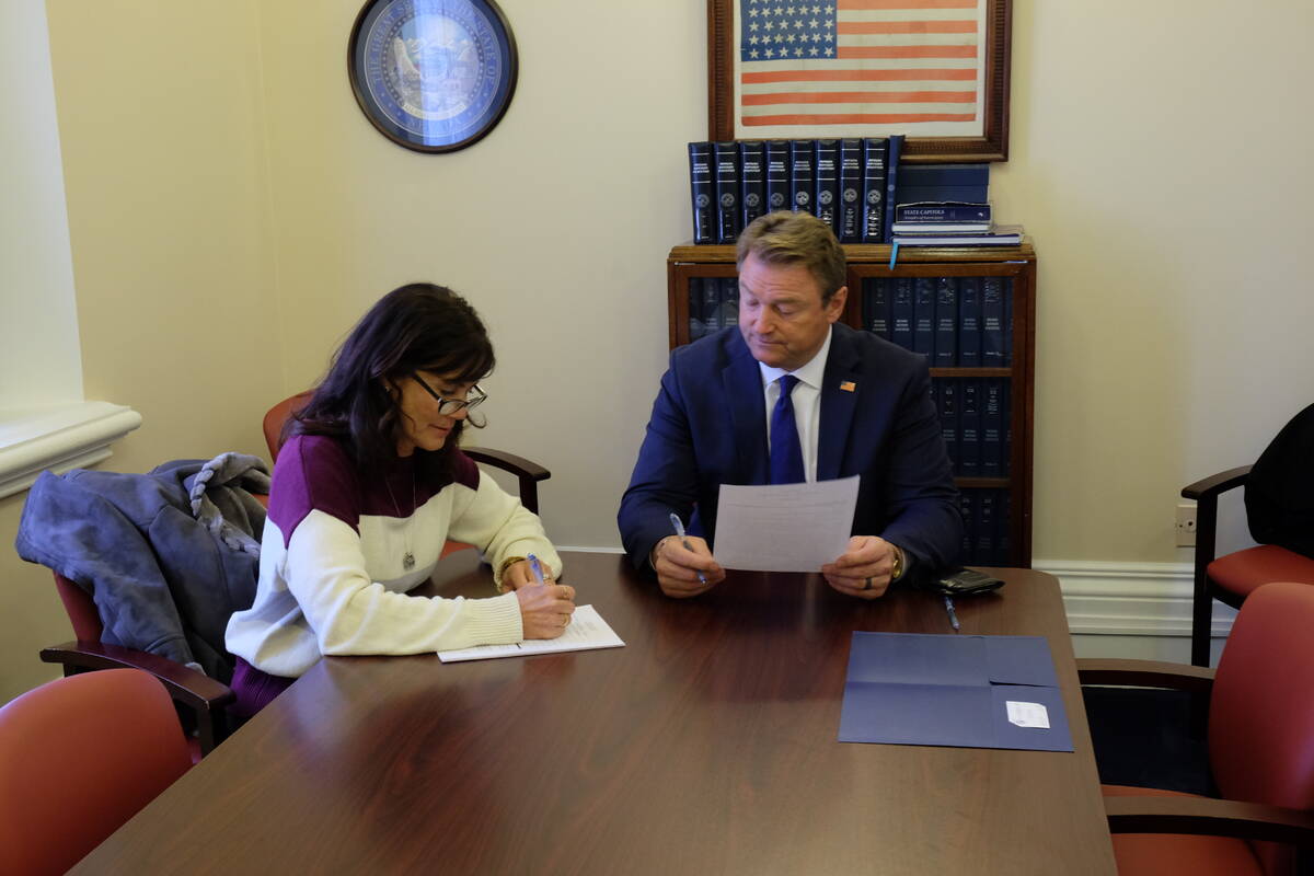Dean Heller is joined by his wife, Lynne, as he completes paperwork in the secretary of state's ...