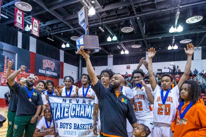 Mojave head coach KeJuan Clark holds the winning trophy as he and players celebrate their win o ...