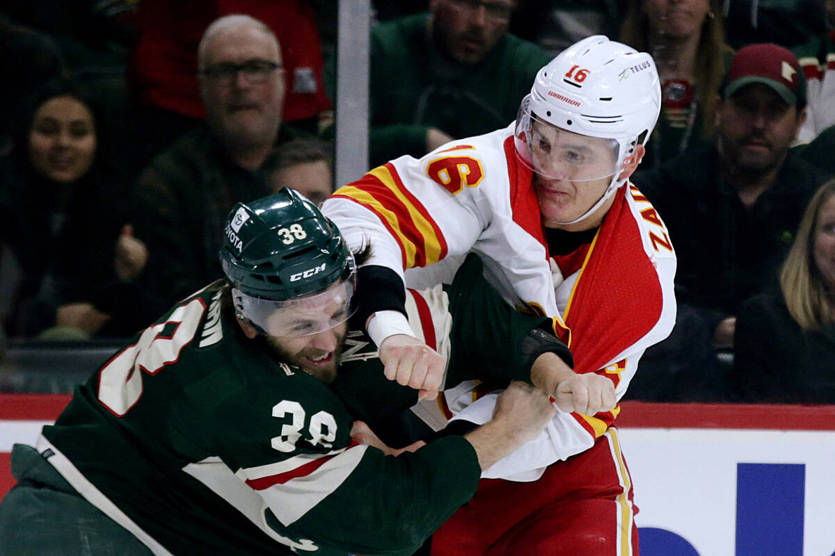 Calgary Flames defenseman Nikita Zadorov (16) and Minnesota Wild right wing Ryan Hartman (38) f ...