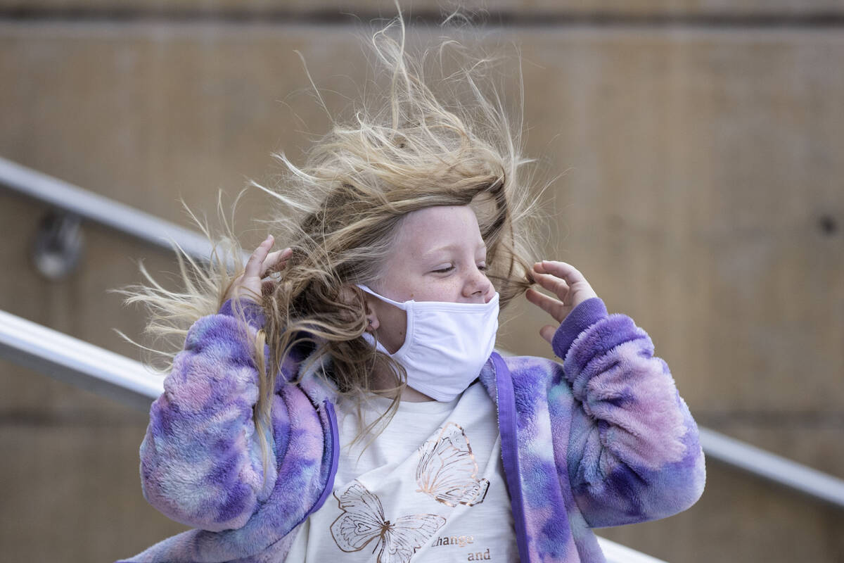 Hope Barett, 7, of Medford, Ore., has her hair blown by strong wind as she enters the Regional ...