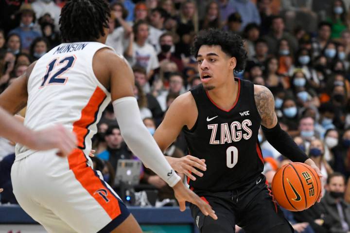 Pepperdine forward Kendall Munson (12) guards Gonzaga guard Julian Strawther (0) during an NCAA ...