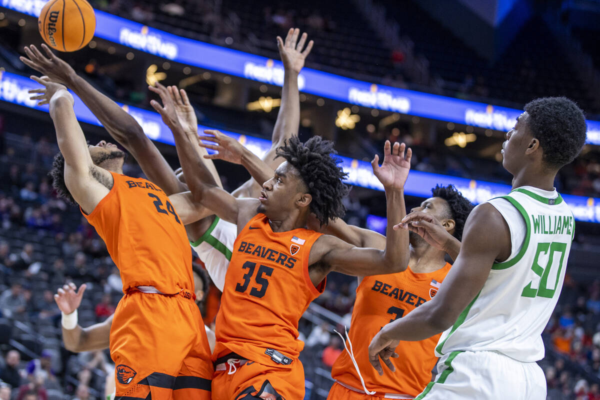 Oregon State Beavers forward Isaiah Johnson (24) battles for a rebound with Oregon Ducks center ...