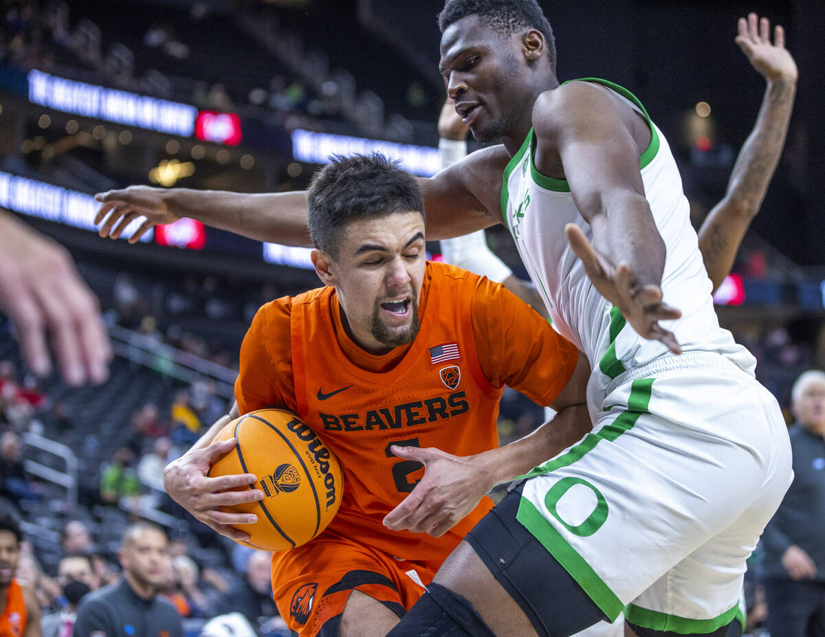 Oregon State Beavers guard Jarod Lucas (2) struggles to find room under the defense of Oregon D ...