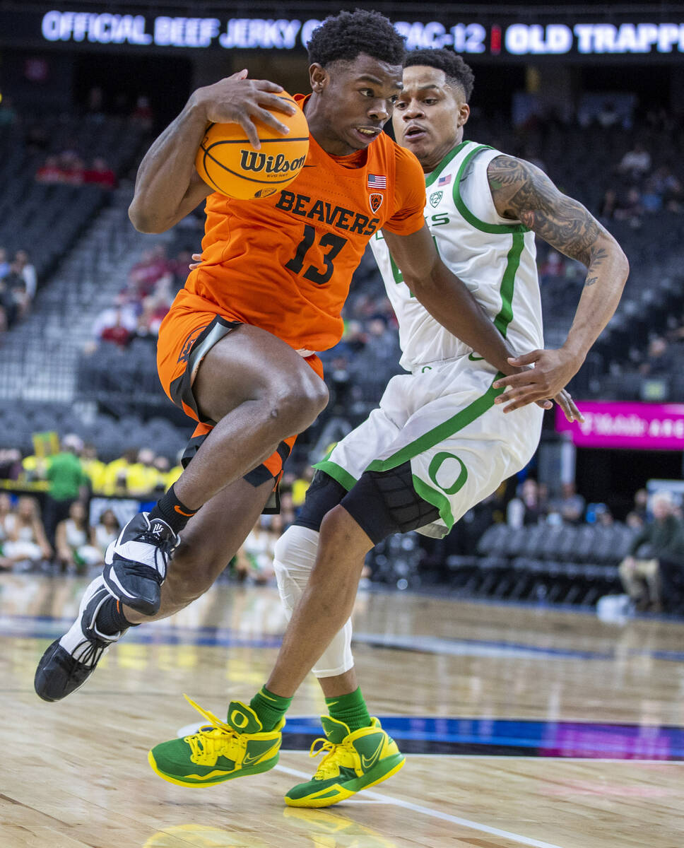 Oregon State Beavers guard Dashawn Davis (13) elevates past Oregon Ducks guard Jacob Young (42) ...