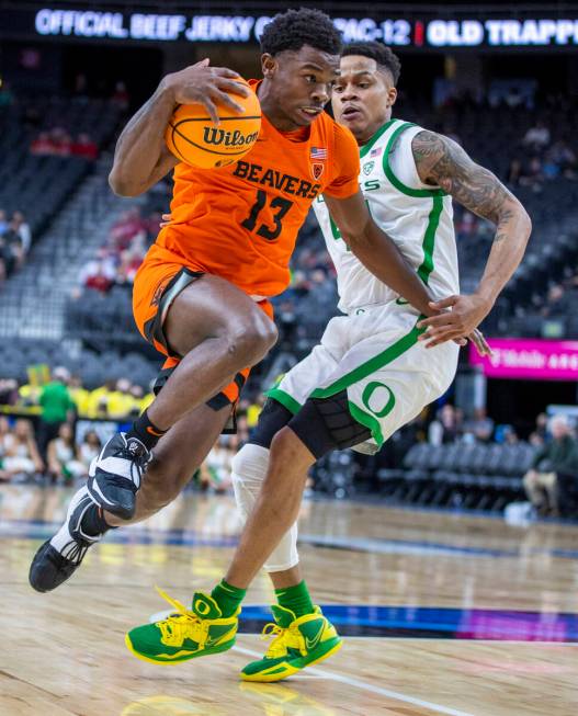 Oregon State Beavers guard Dashawn Davis (13) elevates past Oregon Ducks guard Jacob Young (42) ...