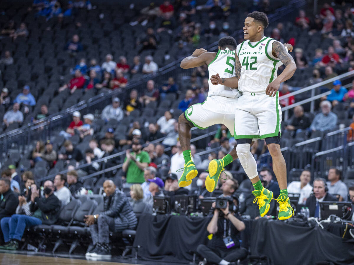 Oregon Ducks guard De'Vion Harmon (5) and teammate guard Jacob Young (42) celebrate a run to d ...