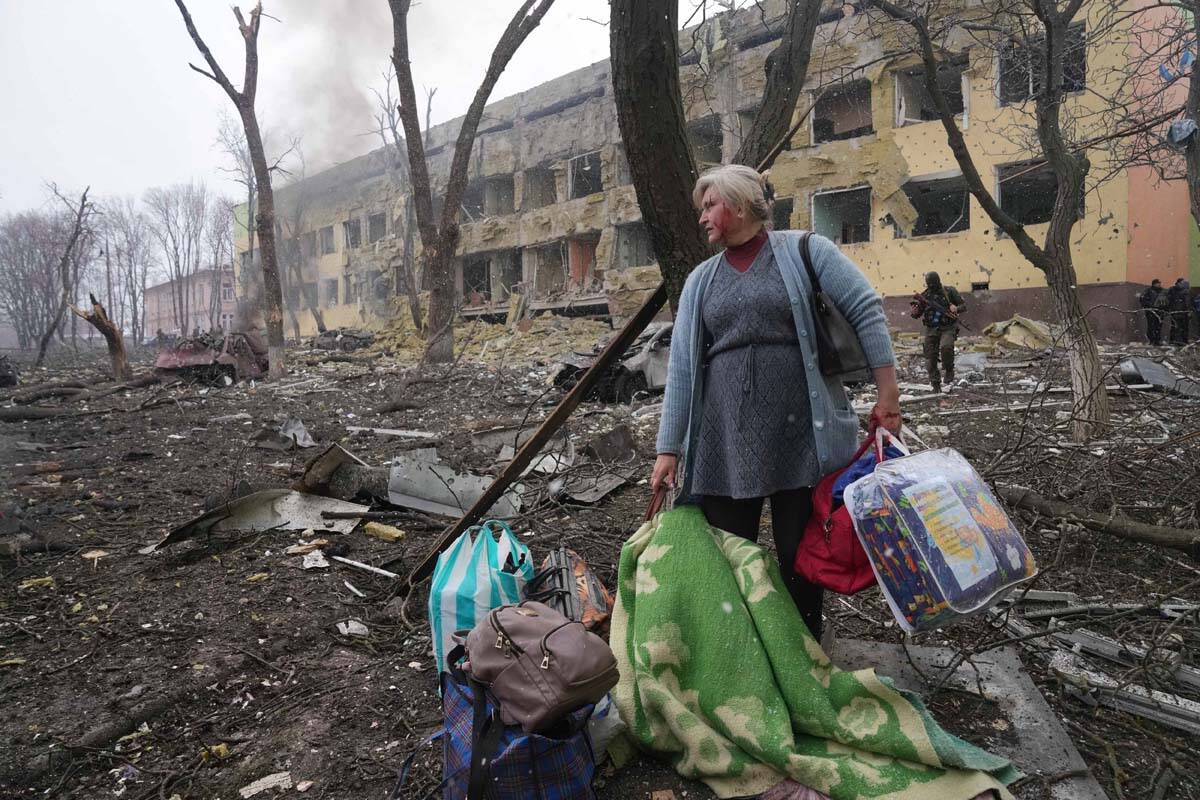 A woman walks outside a maternity hospital that was damaged by shelling in Mariupol, Ukraine, W ...