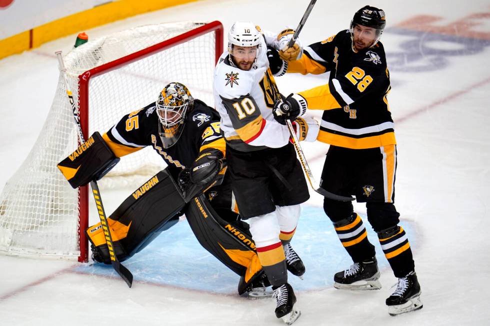 Pittsburgh Penguins' Marcus Pettersson (28) clears Vegas Golden Knights' Nicolas Roy (10) from ...