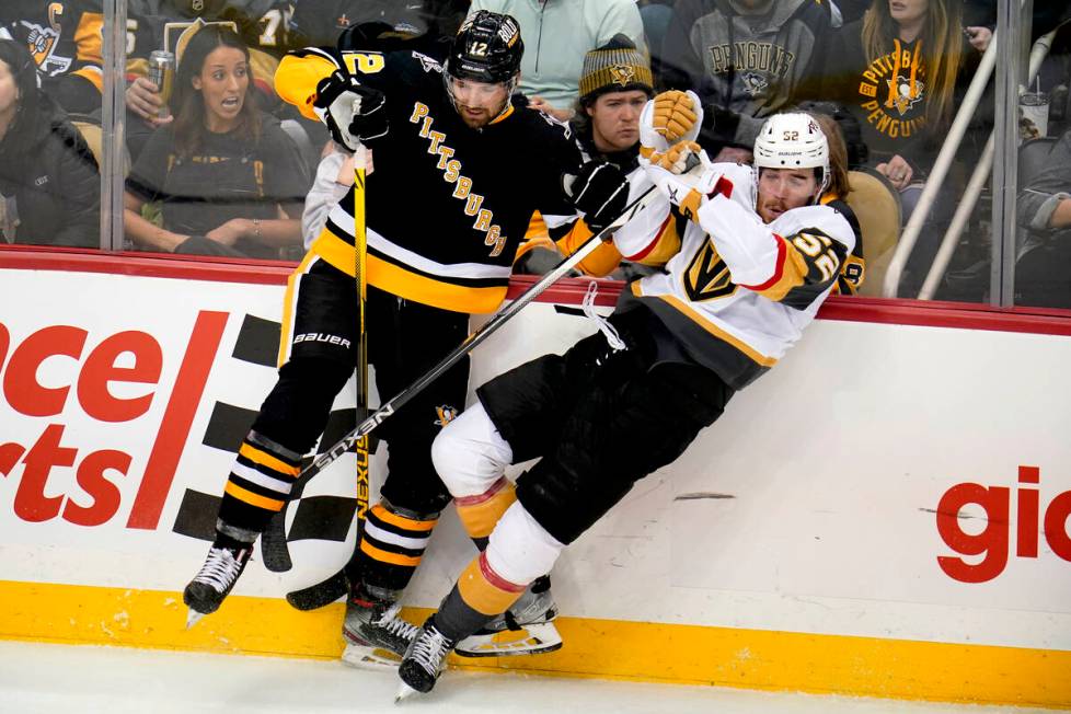 Vegas Golden Knights' Dylan Coghlan (52) is knocked off his skates by Pittsburgh Penguins' Zach ...