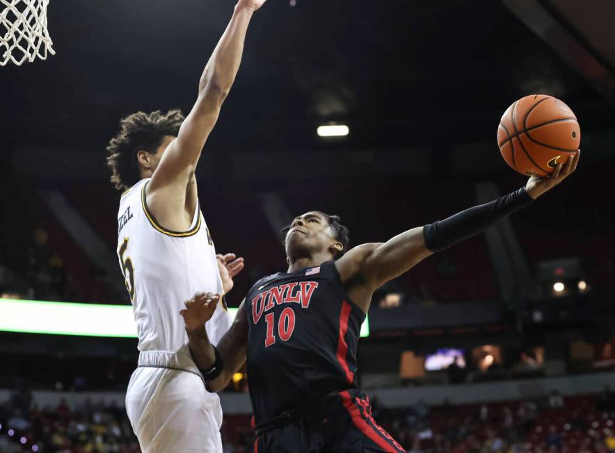 UNLV Rebels guard Keshon Gilbert (10) shoots around Wyoming Cowboys guard Brendan Wenzel (5) du ...