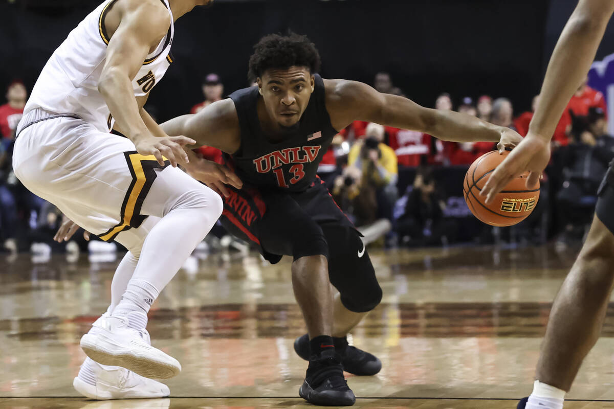 UNLV Rebels guard Bryce Hamilton (13) drives the ball against Wyoming Cowboys guard Brendan Wen ...