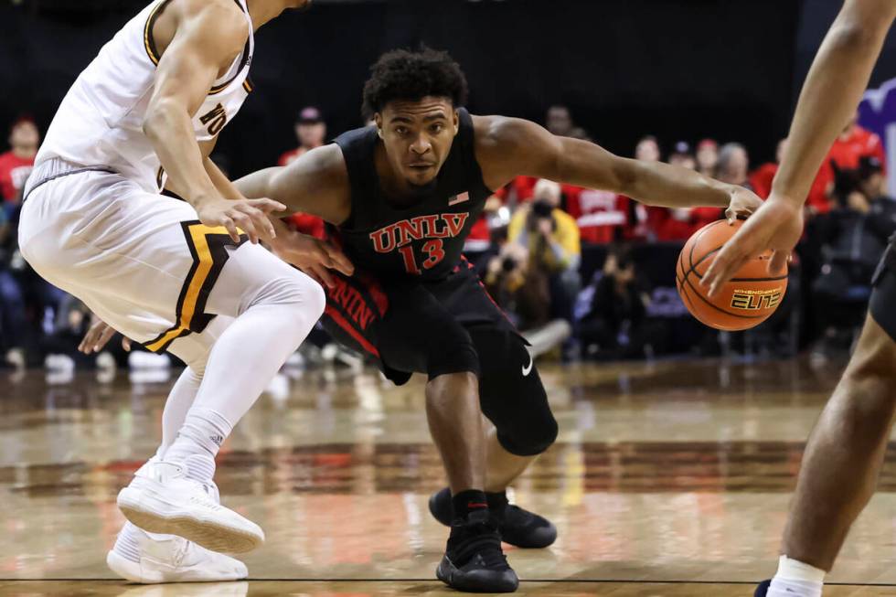 UNLV Rebels guard Bryce Hamilton (13) drives the ball against Wyoming Cowboys guard Brendan Wen ...