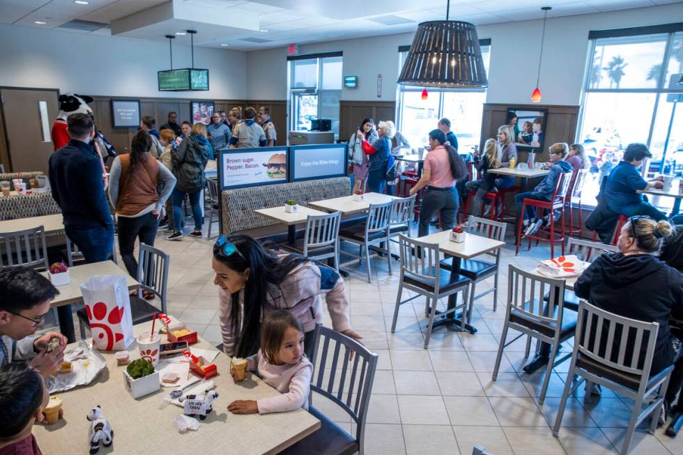 Customers have a bite in the dining room as the new Chick-Fil-A opens complete with a ribbon cu ...