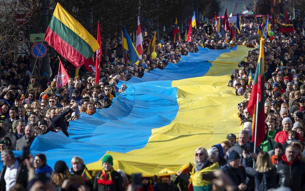 People carry a giant Ukrainian flag to protest against the Russian invasion of Ukraine during a ...