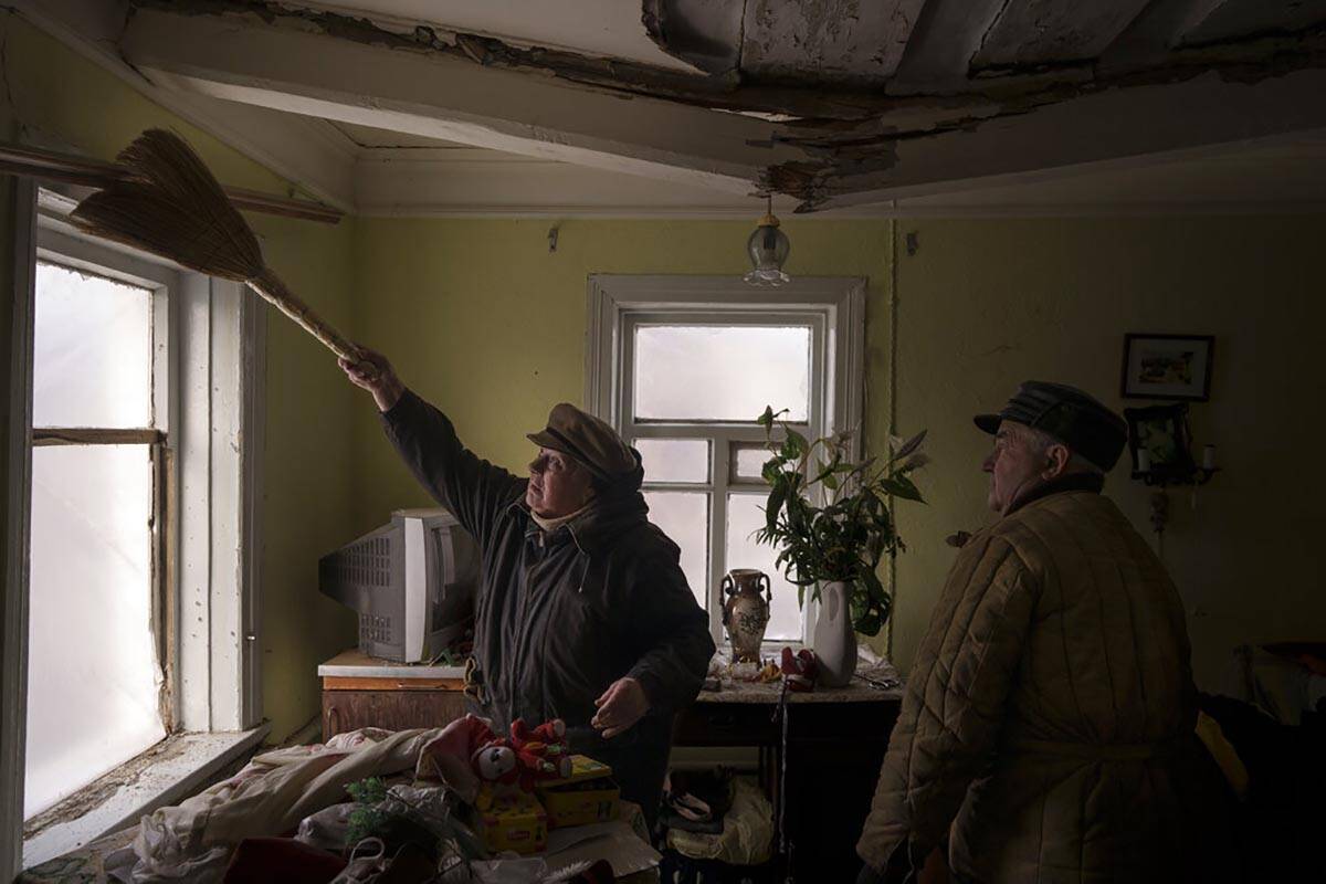 Galina helps clean the house of a neighbour that was damaged by a Russian bombing in Baryshivka ...