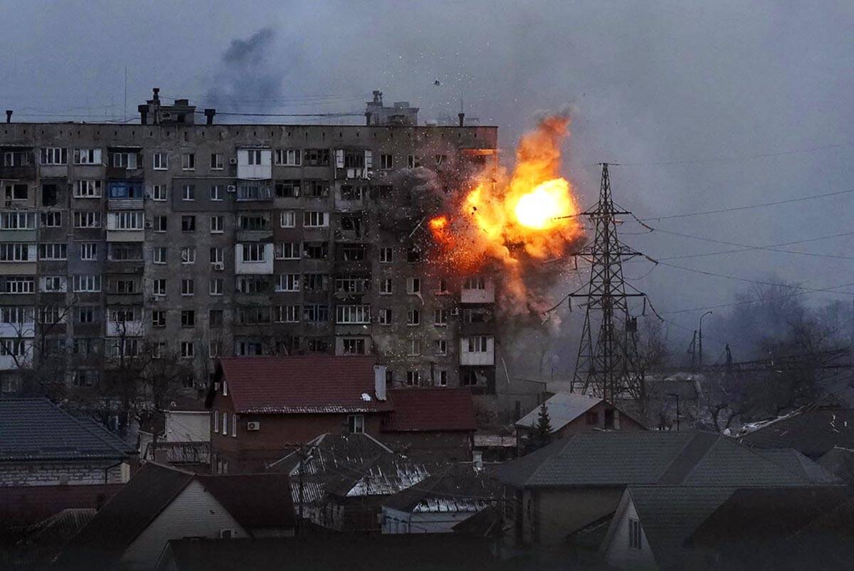 An explosion is seen in an apartment building after Russian's army tank fires in Mariupol, Ukra ...