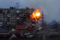 An explosion is seen in an apartment building after Russian's army tank fires in Mariupol, Ukra ...