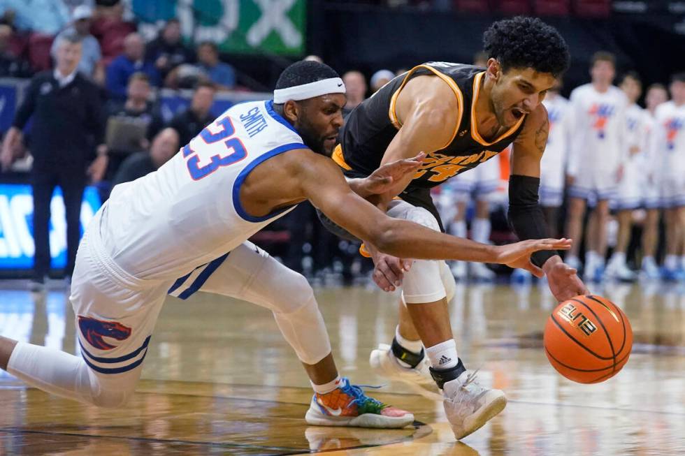 Boise State forward Naje Smith (23) an Wyoming guard Hunter Maldonado (24) scramble for the bal ...