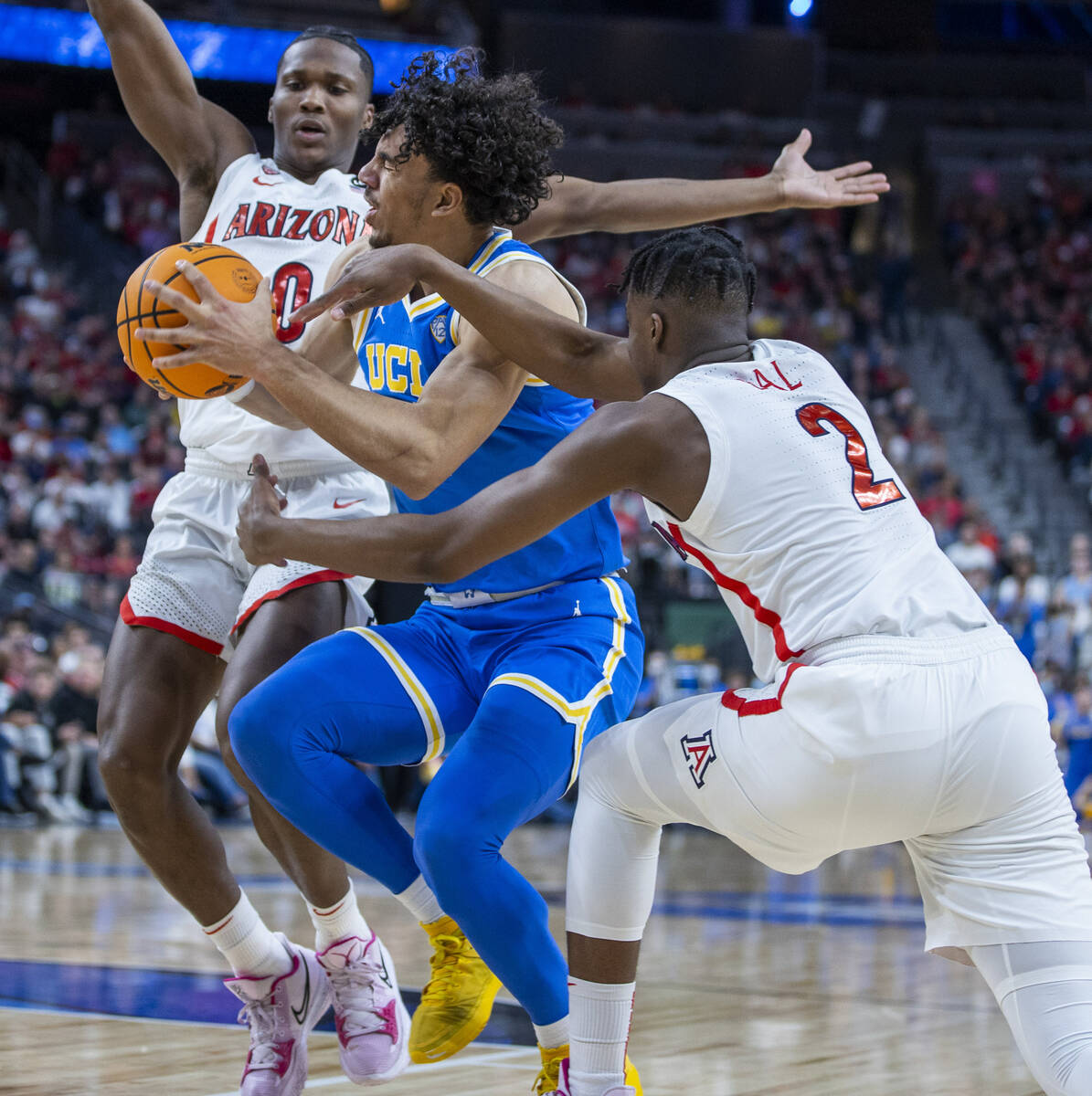 UCLA Bruins guard Jules Bernard (1) is fouled hard by Arizona Wildcats guard Adama Bal (2) with ...