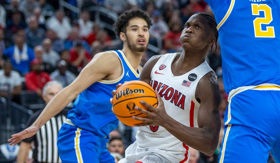 Arizona Wildcats guard Bennedict Mathurin (0) gets past UCLA Bruins guard Johnny Juzang (3) and ...