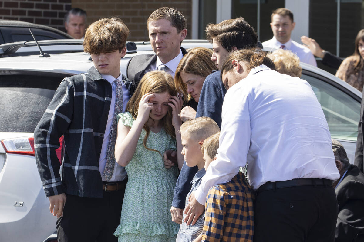 Family members watch as pallbearers carry the casket of Rex Patchett, 13, after his funeral out ...