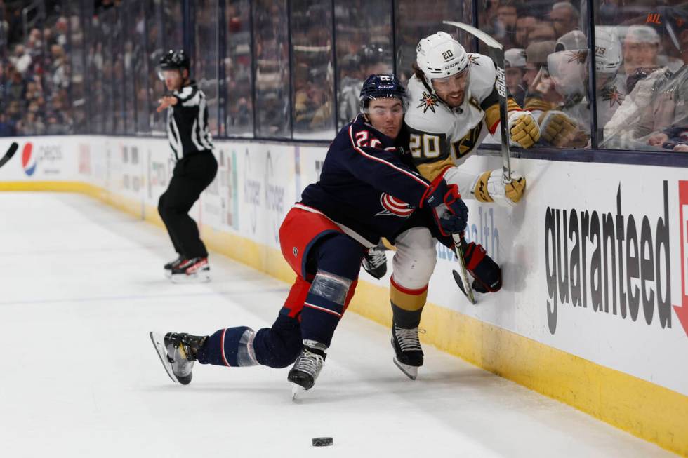 Columbus Blue Jackets' Jake Bean, front left, checks Vegas Golden Knights' Chandler Stephenson ...