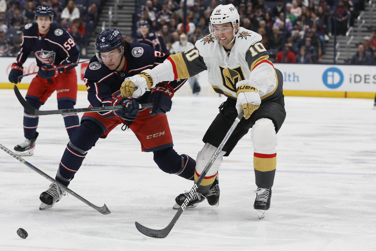 Columbus Blue Jackets' Andrew Peeke, left, and Vegas Golden Knights' Nicolas Roy chase the puck ...