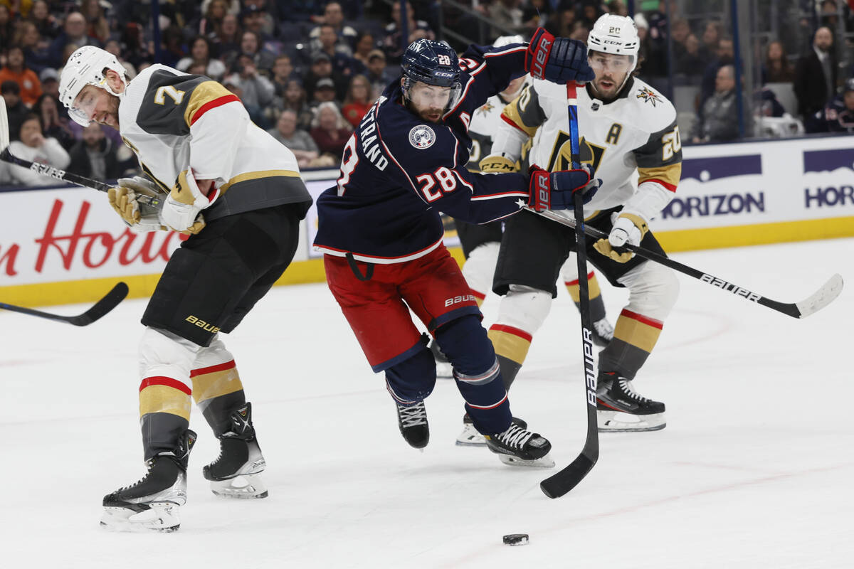 Columbus Blue Jackets' Oliver Bjorkstrand, center, skates between Vegas Golden Knights' Alex Pi ...