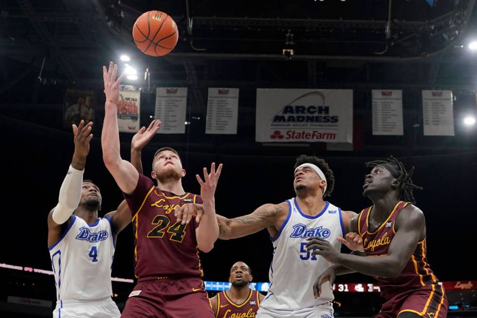 Loyola of Chicago's Tate Hall (24) and Drake's ShanQuan Hemphill (4) reach for a rebound as Dra ...