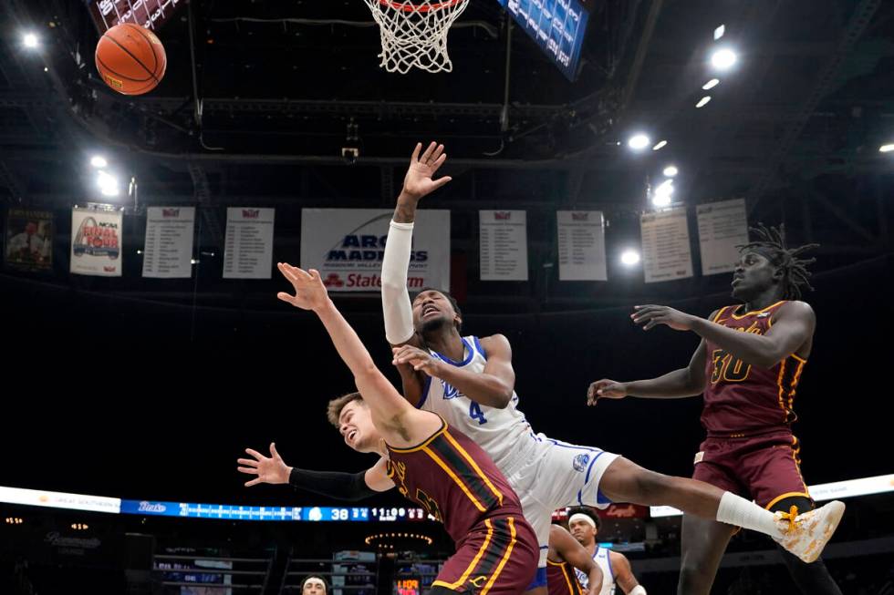 Drake's ShanQuan Hemphill, center, loses control of the ball as Loyola of Chicago's Braden Norr ...