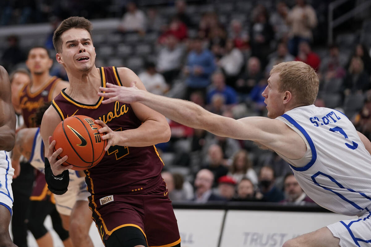 Loyola of Chicago's Braden Norris (4) heads to the basket as Drake's Garrett Sturtz (3) defends ...