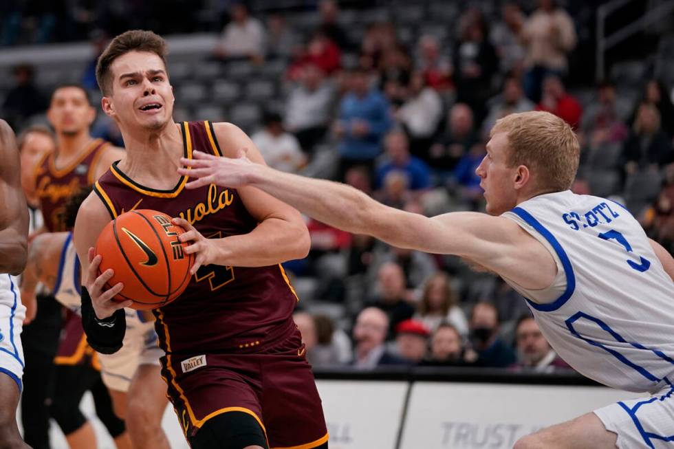 Loyola of Chicago's Braden Norris (4) heads to the basket as Drake's Garrett Sturtz (3) defends ...